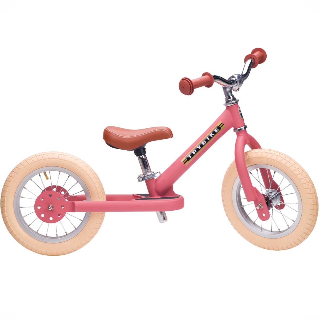 Trybike Steel 2-in-1 loopfiets in vintage roze als tweewieler met bruin zadel en crème banden.