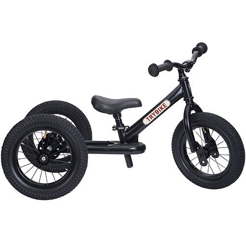 Zwarte Trybike stalen 2-in-1 loopfiets in driewieler configuratie, schuin van voren gefotografeerd.