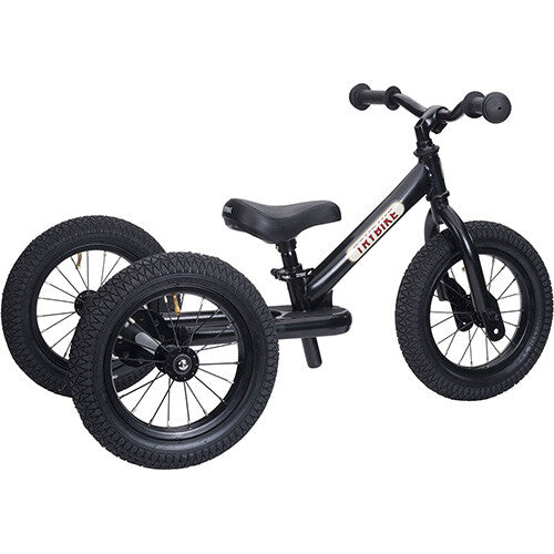 Zwarte Trybike stalen 2-in-1 loopfiets in driewieler configuratie, schuin van voren gefotografeerd.