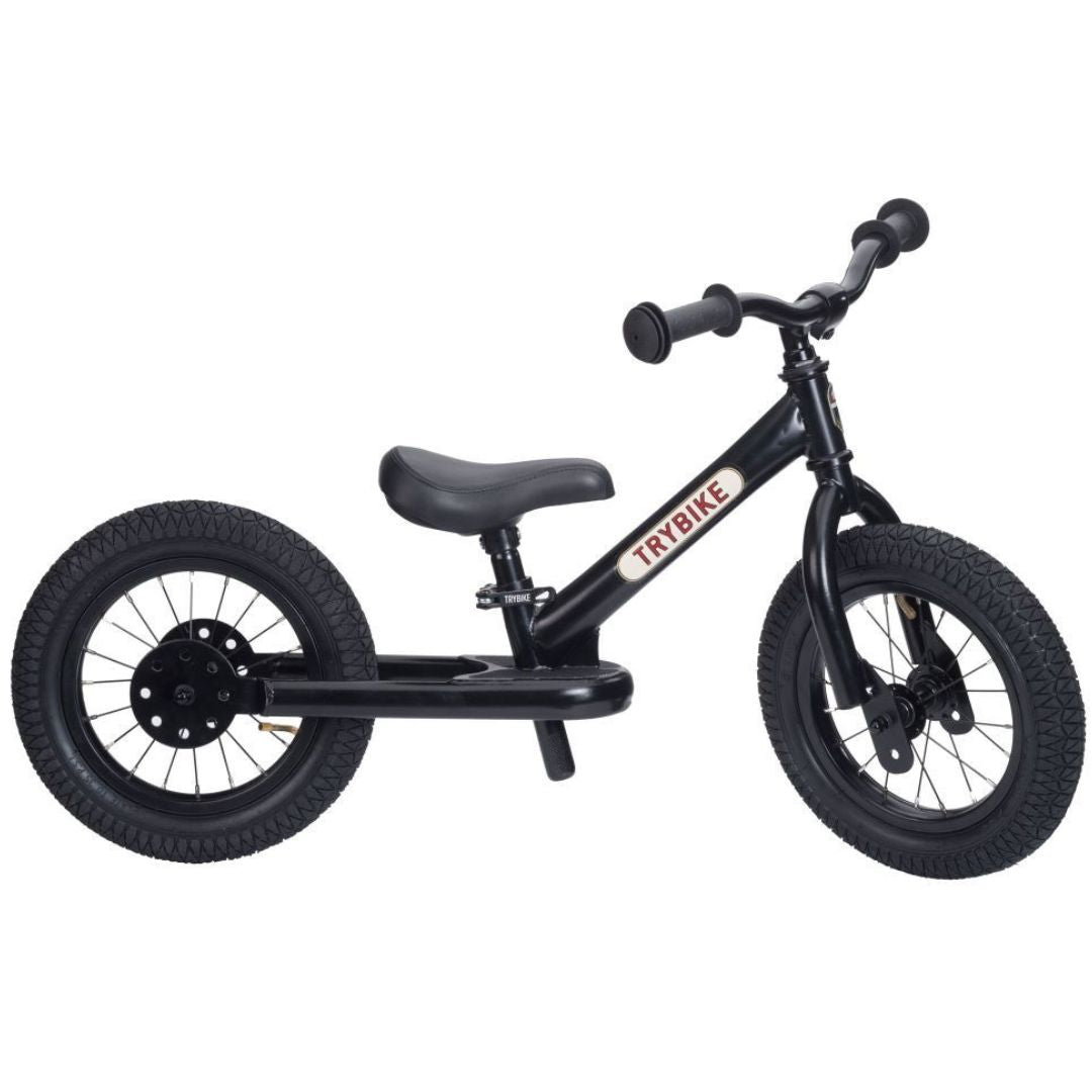 Zwarte Trybike stalen 2-in-1 loopfiets in tweewieler configuratie, van de zijkant gefotografeerd.