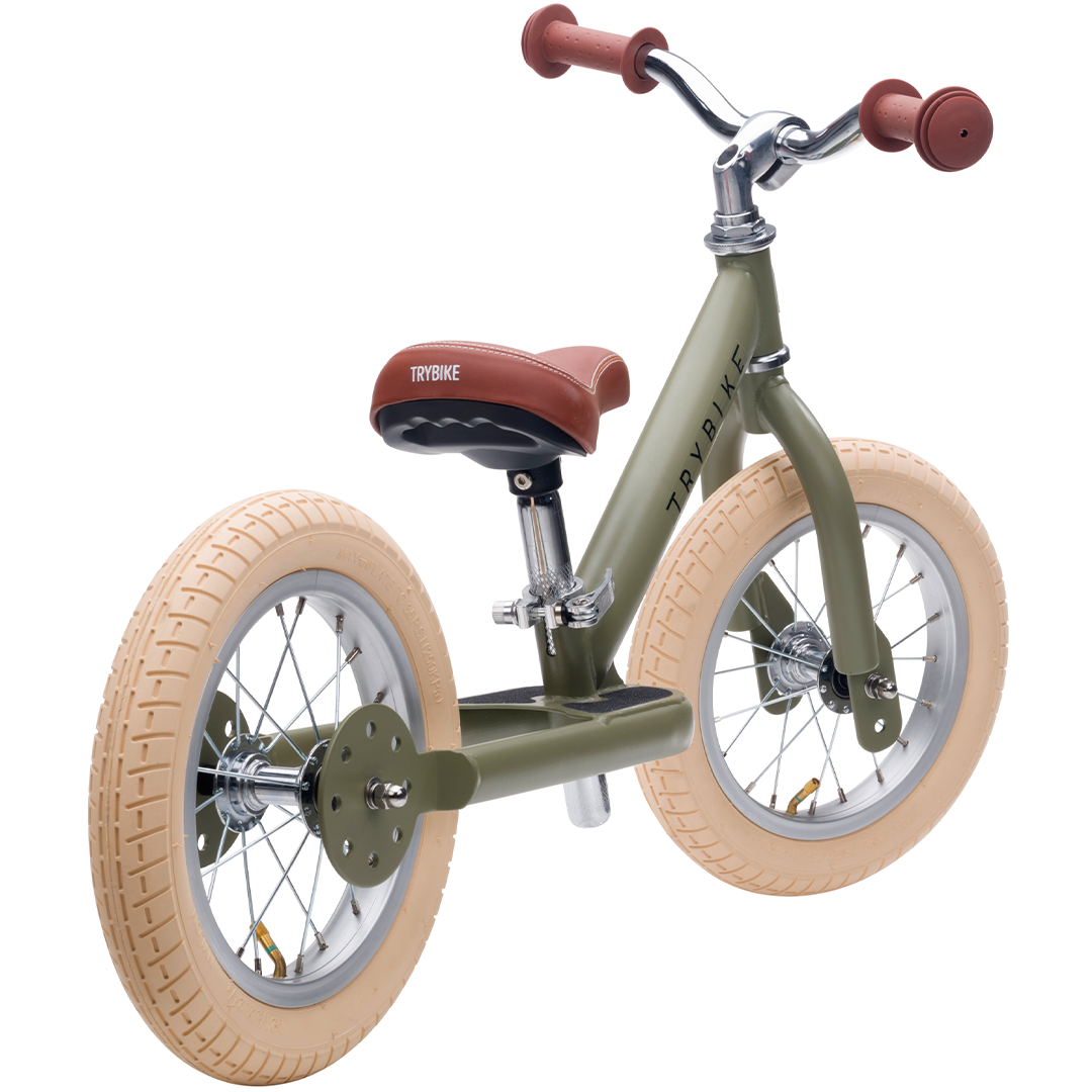 Trybike stalen loopfiets in vintage groen, schuin van achteren gezien.