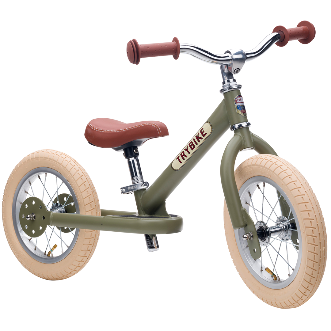 Trybike stalen loopfiets in vintage groen, schuin van voren gezien.