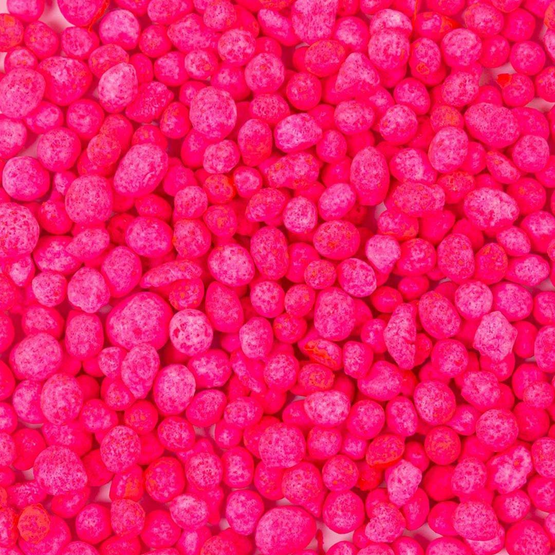 Detailopname van felroze minerale balletjes met textuur.