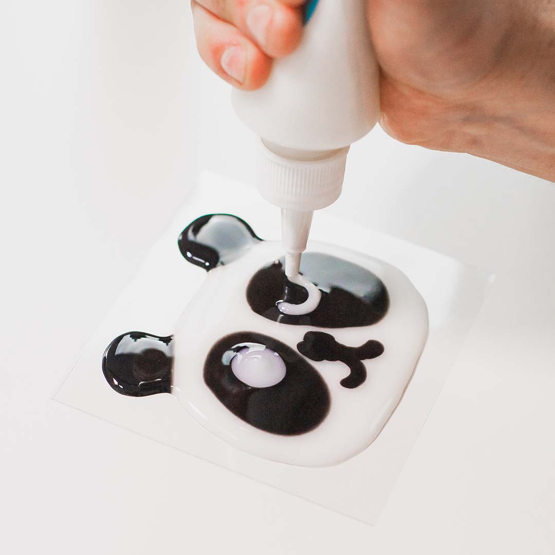 Een hand vult een panda-gezicht met witte Tubi Jelly.