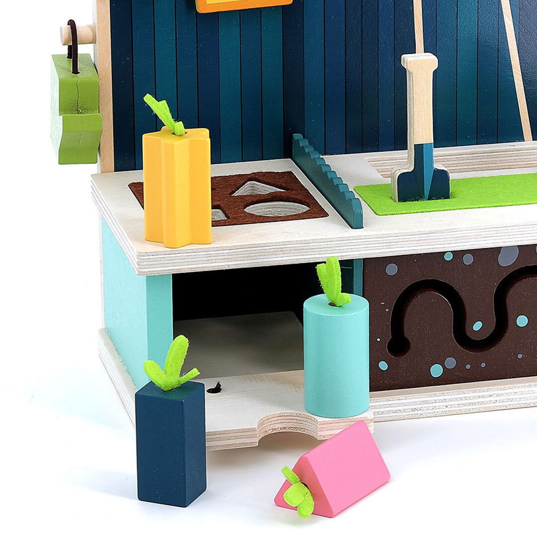 Detail van de Vilac activiteitentafel met houten wortels, schep en wormenbaan.
