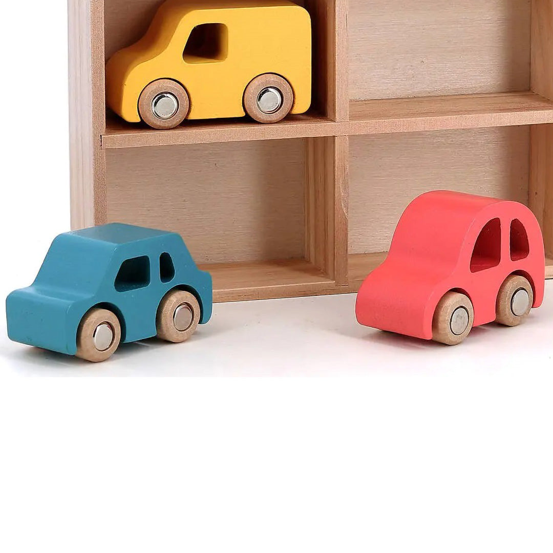 Twee Vilac houten speelgoedauto's, een teal en een rode, staan voor een houten opbergrek.
