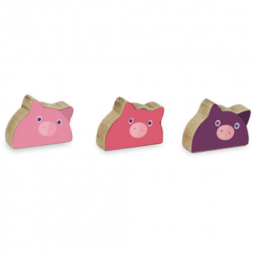 Drie houten biggetjes speelfiguren in roze, rood en paars.