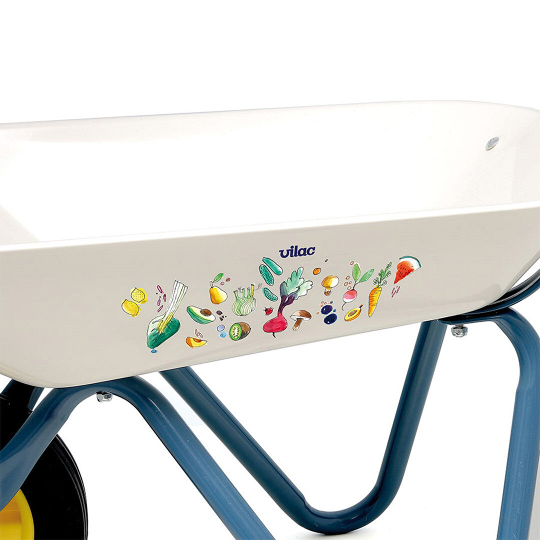 Detail van de Vilac kinderkruiwagen met het logo en een kleurrijk patroon van groenten en fruit.