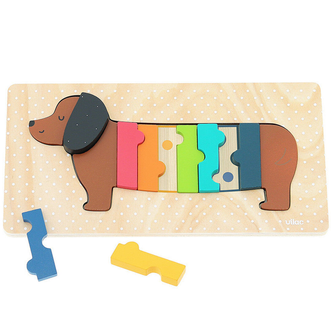 Vilac houten teckel puzzel voor peuters met kleurrijke stukken en twee losse puzzelstukken ernaast.