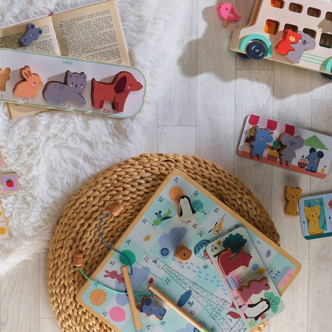Vilac houten spelletjesdoos voor peuters met bordspel en diverse houten dierenpuzzels, liggend op een witte ondergrond.