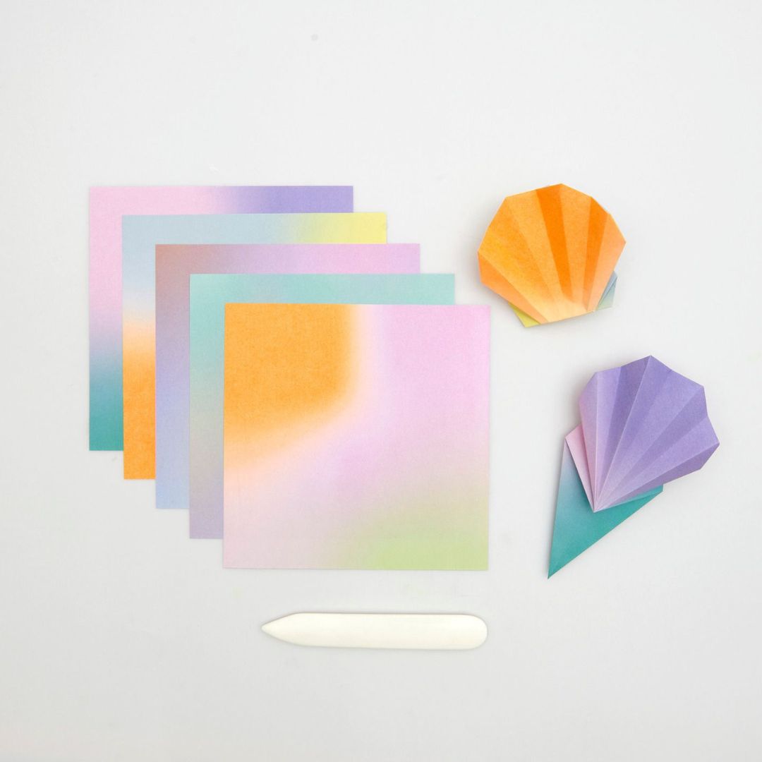 Vellen Rico Design origami papier met blurry gradient patroon en twee gevouwen origami figuren.