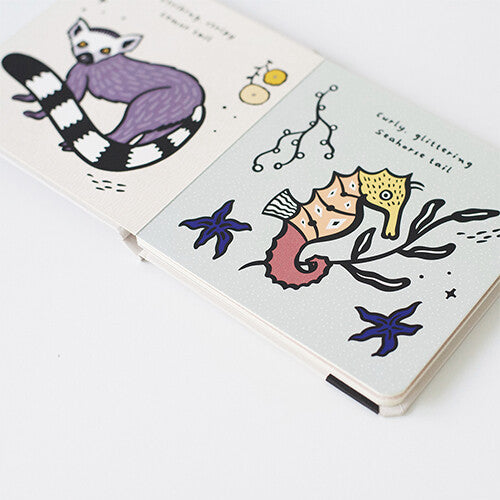 Een schuine detailfoto van open pagina's van het wee gallery voelboek met een maki en een zeepaardje.
