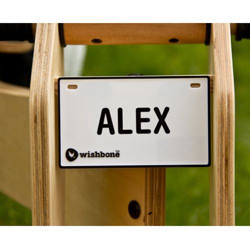 Wishbone bike wit naamplaatje met de naam ALEX, bevestigd aan een houten loopfiets.