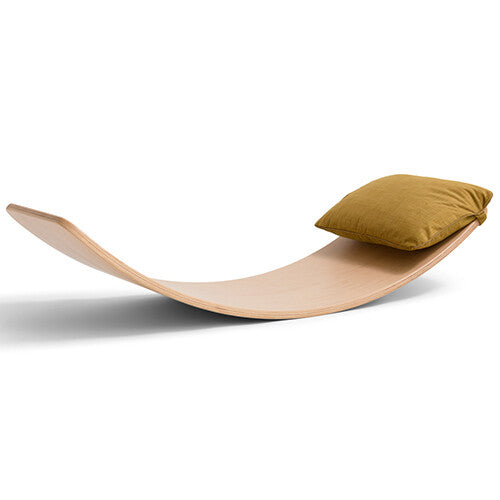 Wobbel okerkleurig kussen liggend op een houten wobbel board.
