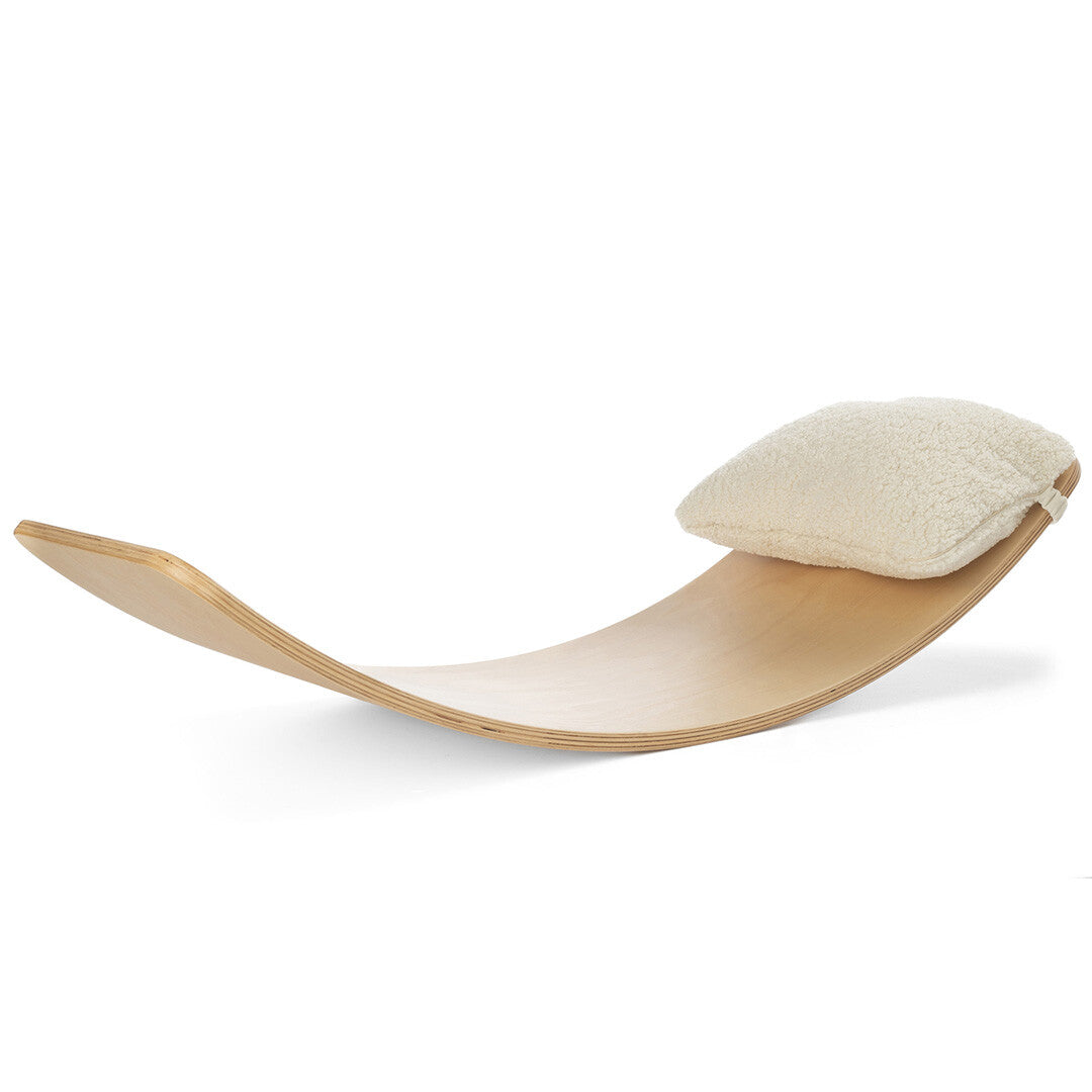 Wobbel teddy kussen voor XL als hoofdsteun op een houten wobbel board.