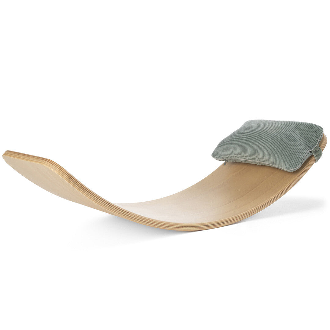 Wobbel corduroy kussen in soft sea kleur als hoofdsteun op een houten Wobbel board.