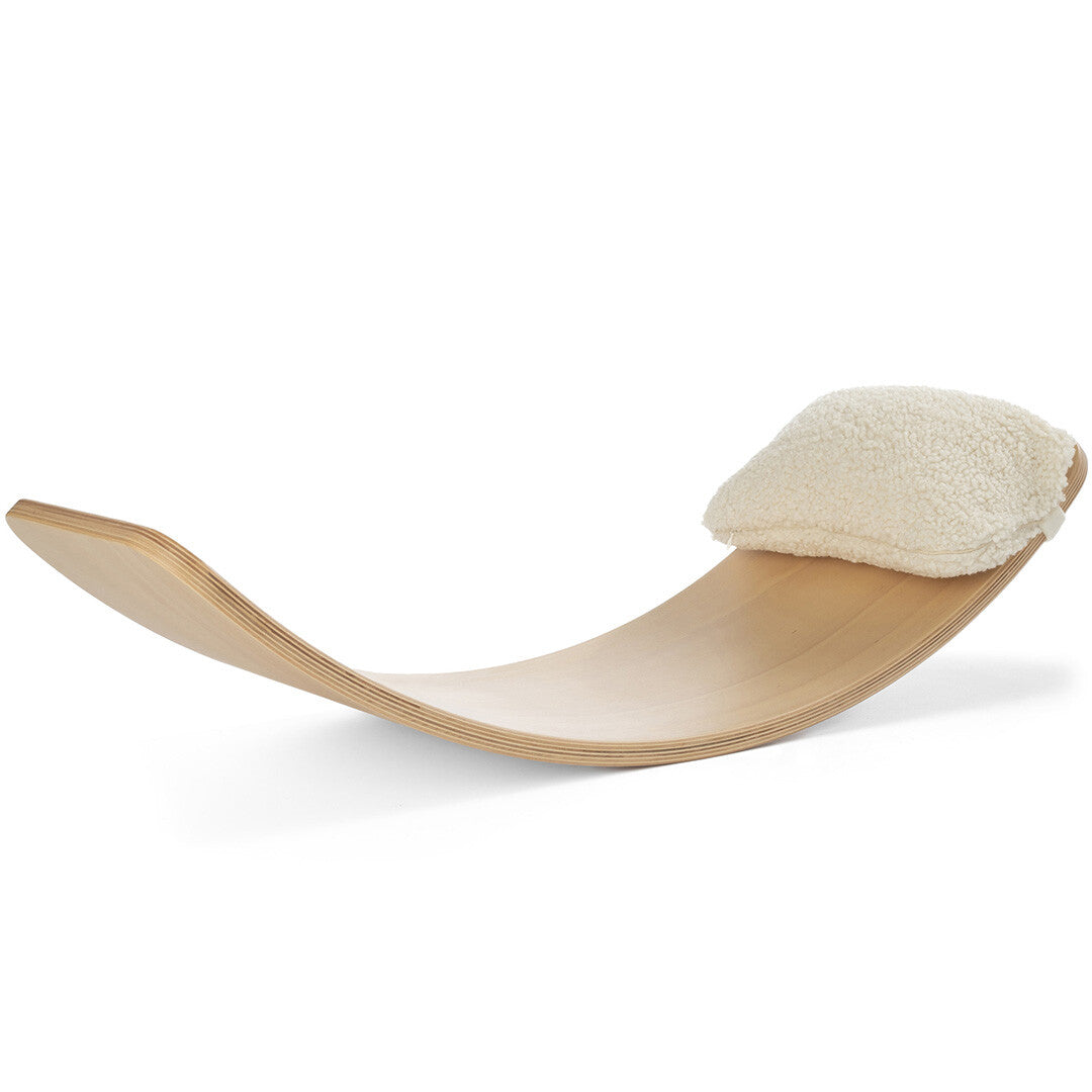 Wobbel teddy kussen als hoofdsteun op een houten wobbel board.