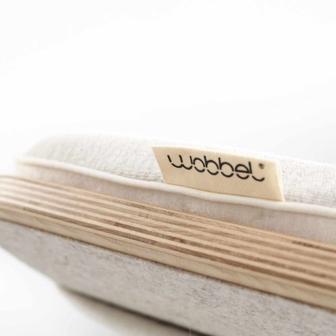 Detail van het Wobbel matras met het Wobbel merklabel en de houten rand van het board.