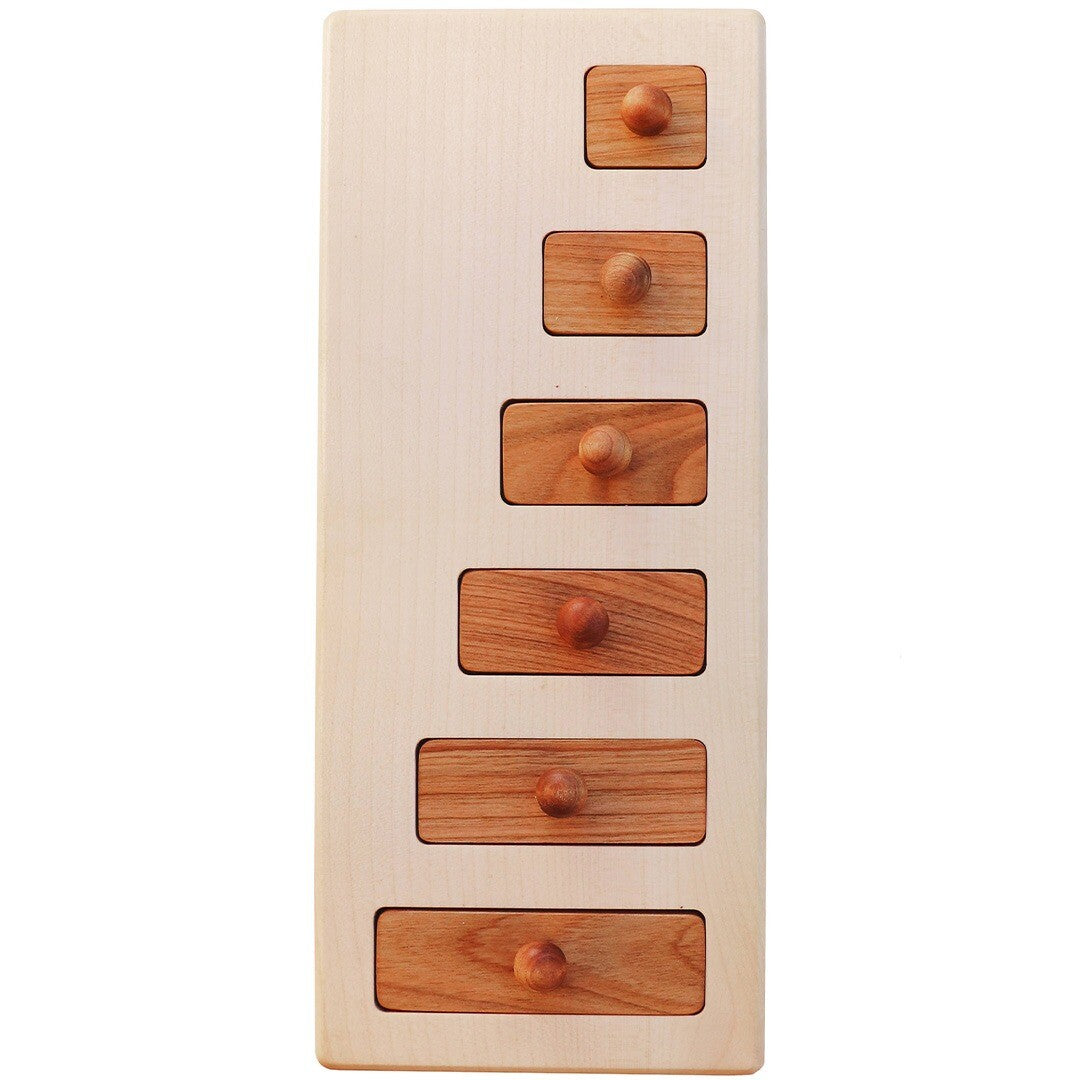 Wooden Story houten knoppuzzel met zes bruine houten blokjes van verschillende lengtes in een lichte houten plank.