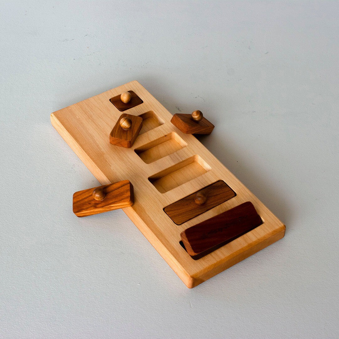 Wooden Story houten knoppuzzel schuin van bovenaf gezien, met enkele bruine houten blokjes uit de lichte houten plank.