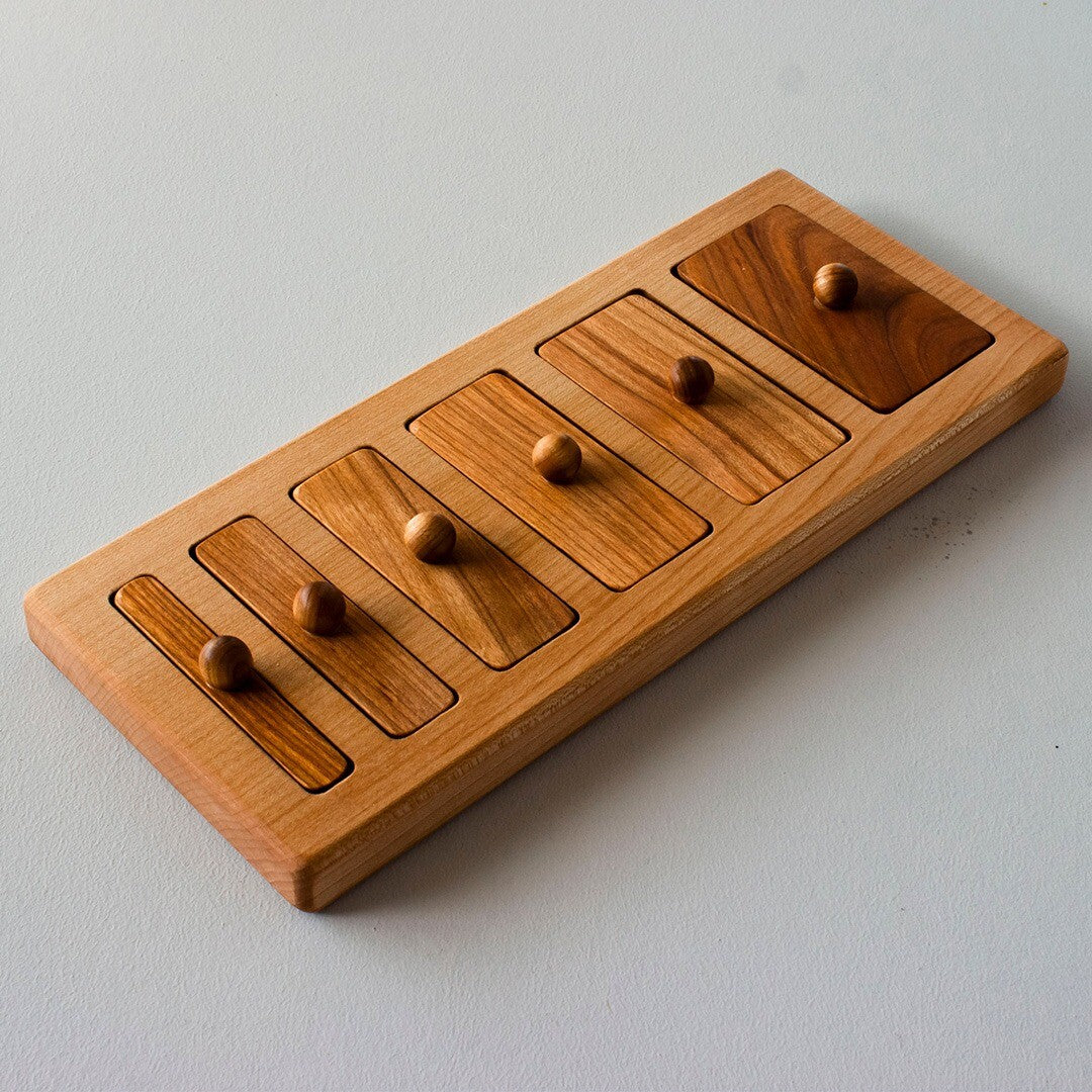 Wooden Story houten knoppuzzel met zes rechthoekige stukken in een houten frame, schuin van bovenaf gefotografeerd.