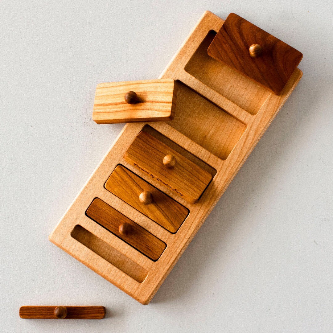 Wooden Story houten knoppuzzel met enkele rechthoekige stukken uit het frame gehaald, gezien van bovenaf.