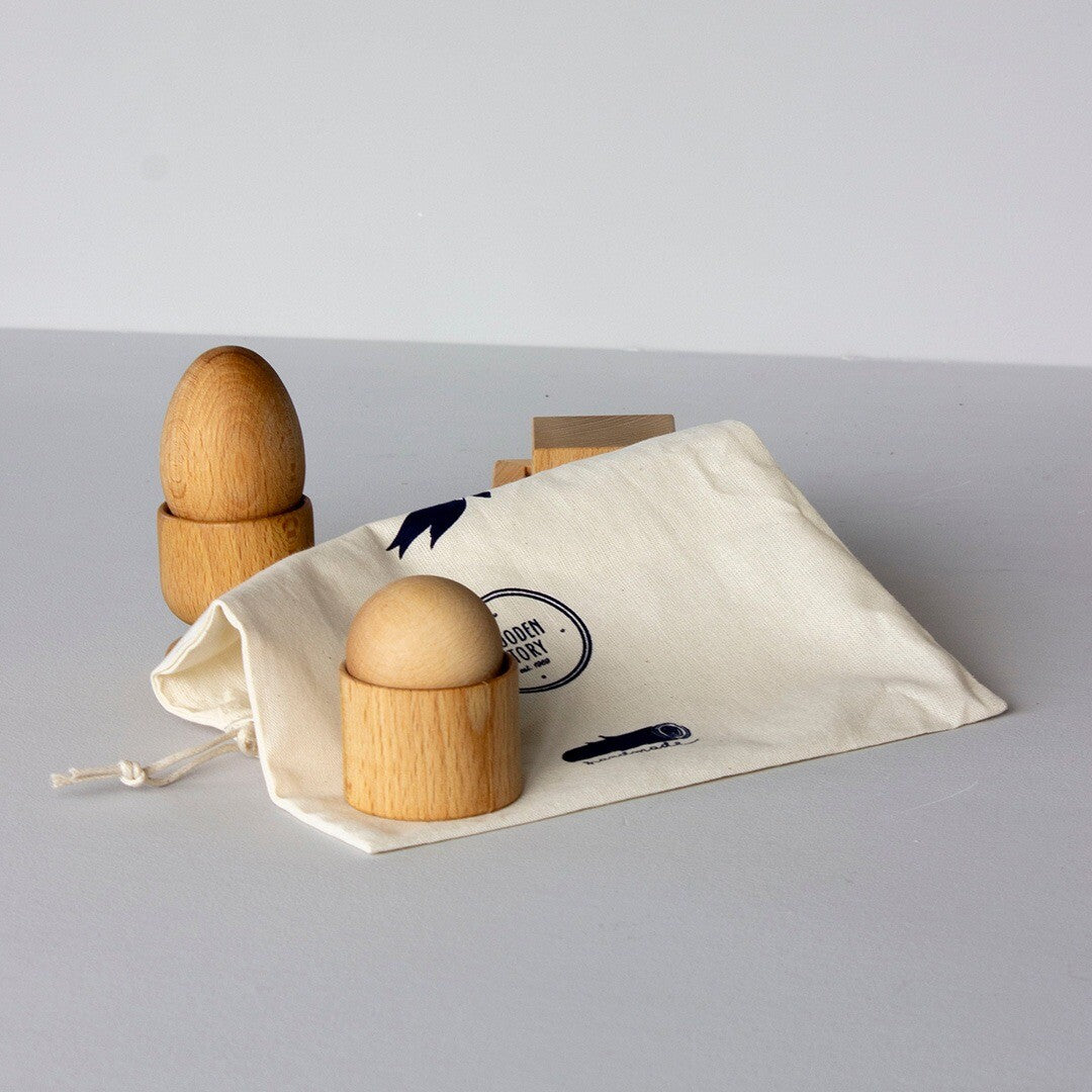 Wooden Story houten Montessori sorteervormen en een stoffen opbergzakje met logo, schuin van bovenaf gezien.