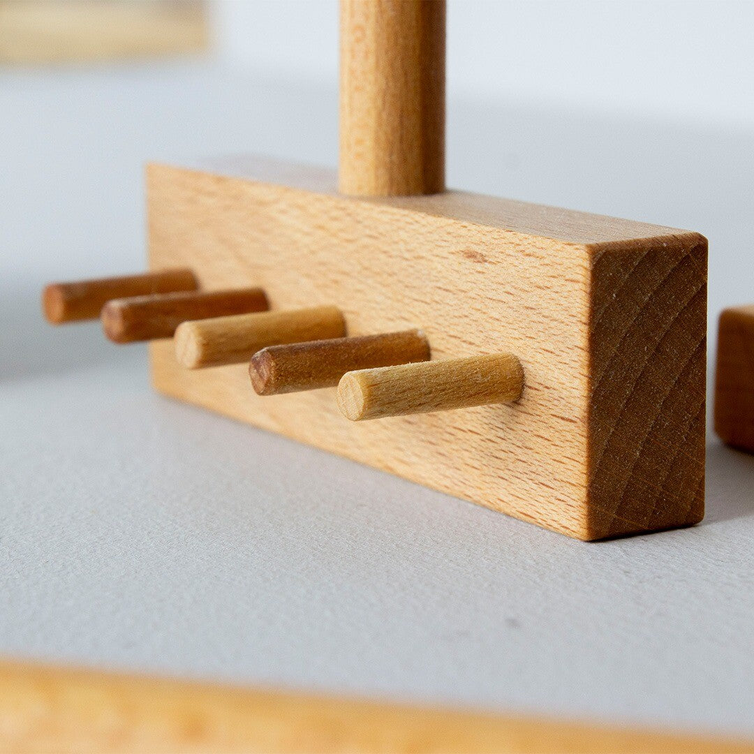 Detail van een Wooden Story houten speelbak accessoire met vier ronde pinnen.