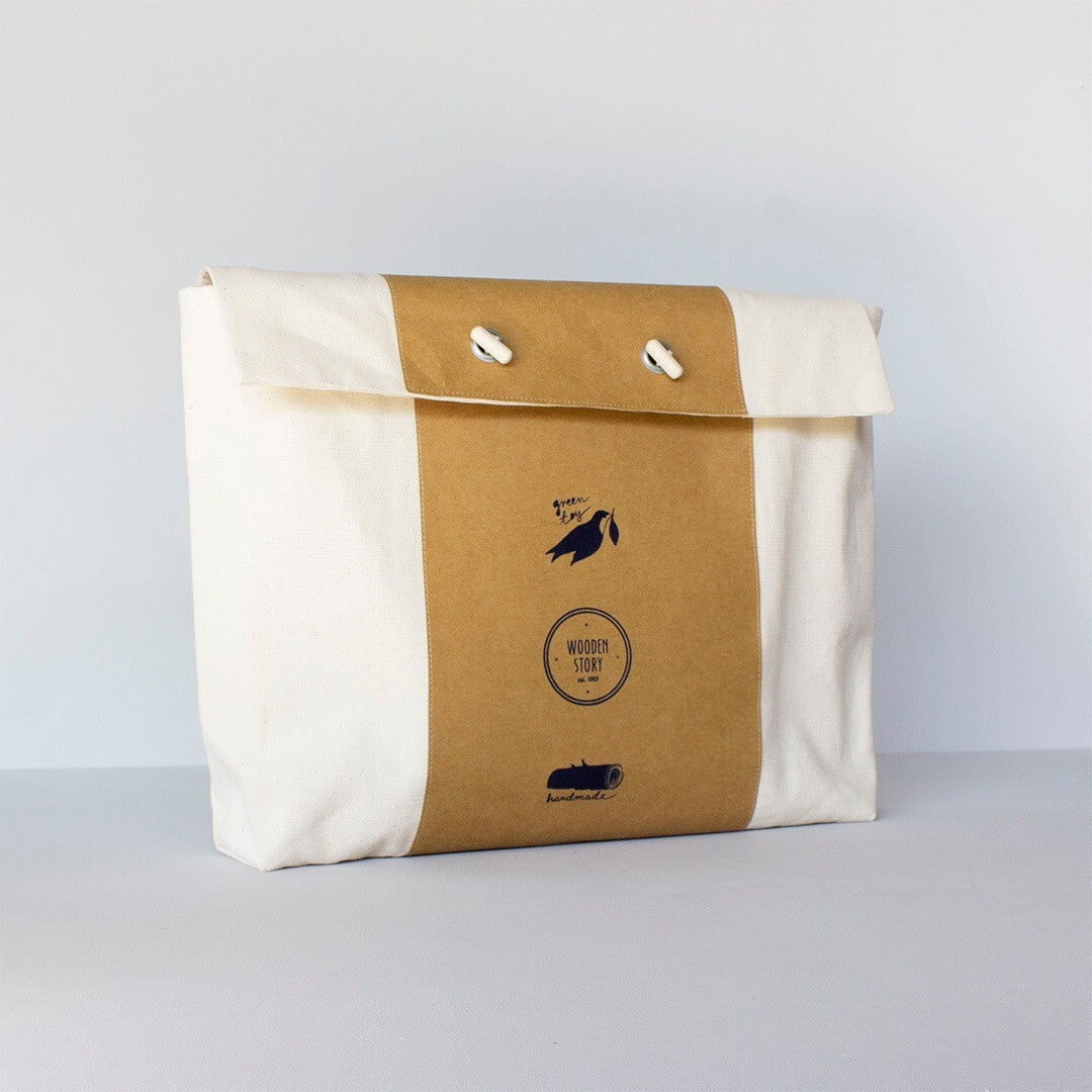 Verpakking van de Wooden Story speelbak, een witte canvas tas met bruine band en logo.