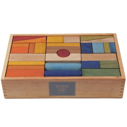 Wooden Story houten bouwblokken in regenboogkleuren netjes gerangschikt in een houten kist.
