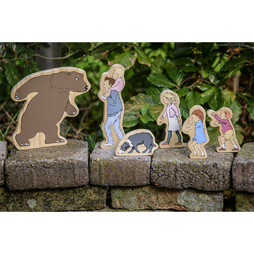 Yellow Door houten speelfiguren van de 'We're Going on a Bear Hunt' set, staand op een stenen muur.