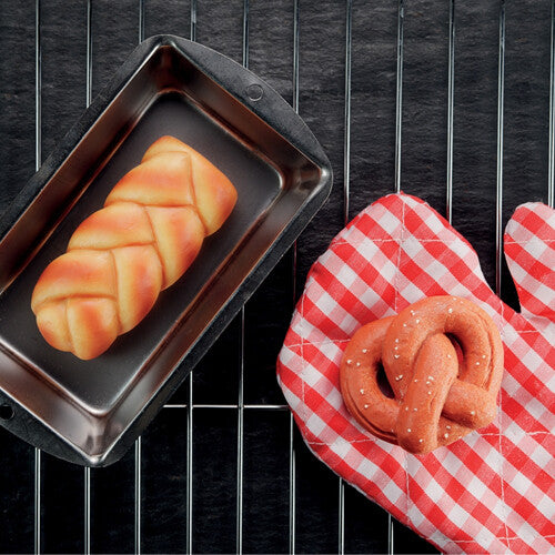 Een gevlochten yellow door broodje speelgoedsteen in een bakvorm en een krakeling op een ovenwant op een rooster.