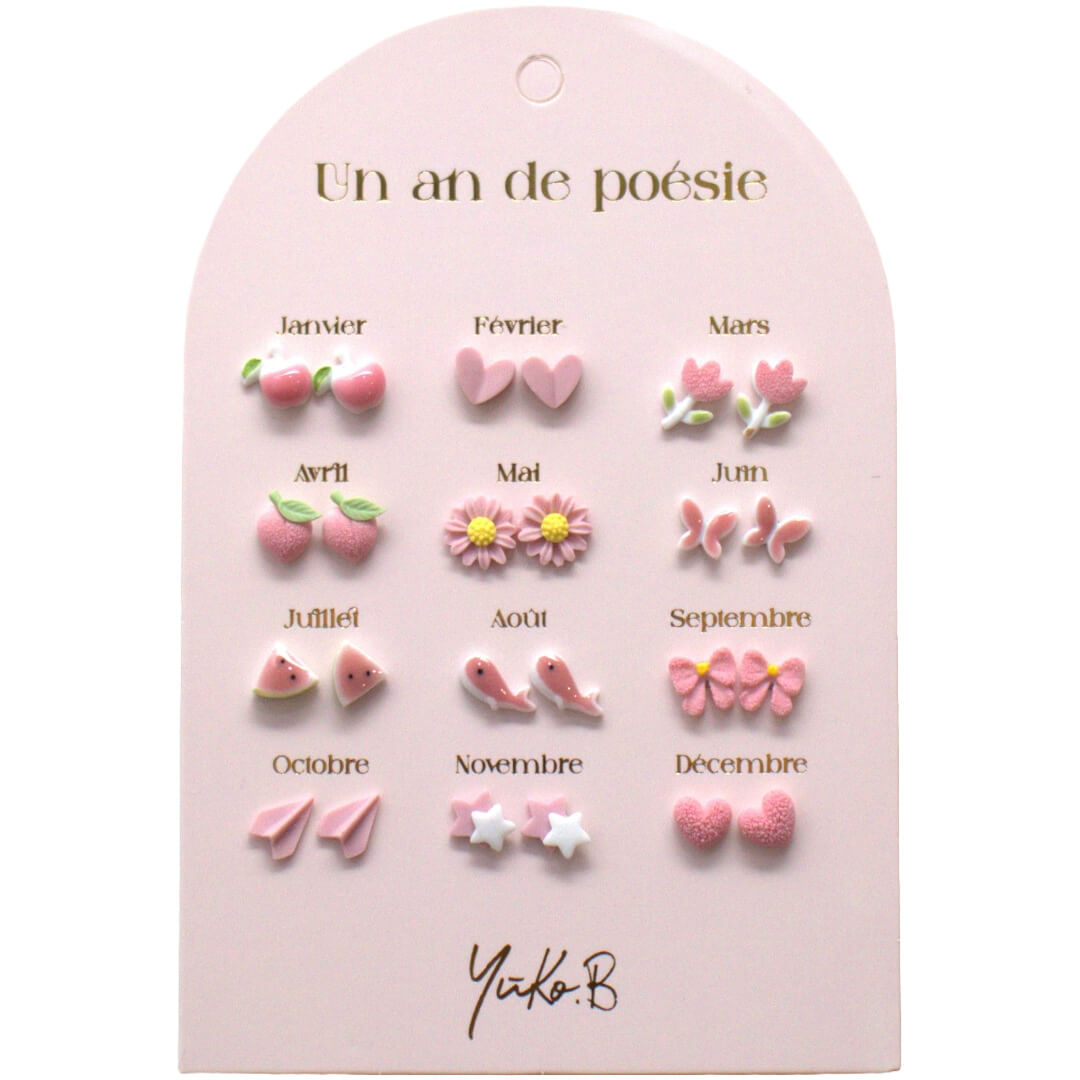 Yuko B. kinder oorbellen set met 12 paar roze oorknopjes in verschillende vormen, gepresenteerd op een roze kaart.