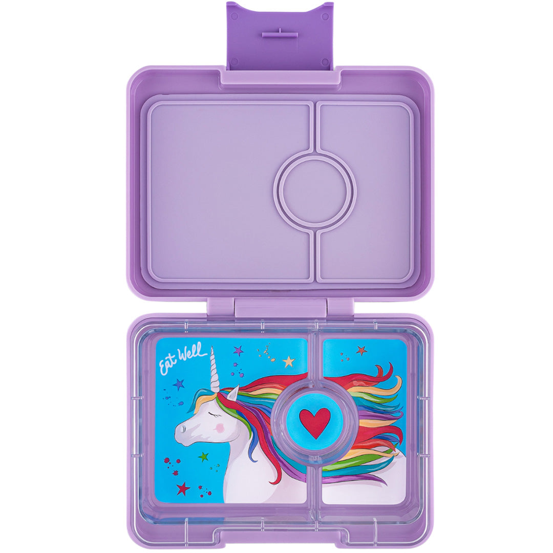 Een open paarse Yumbox snack bento lunchdoos met drie vakken en een eenhoorn met regenboogmanen.