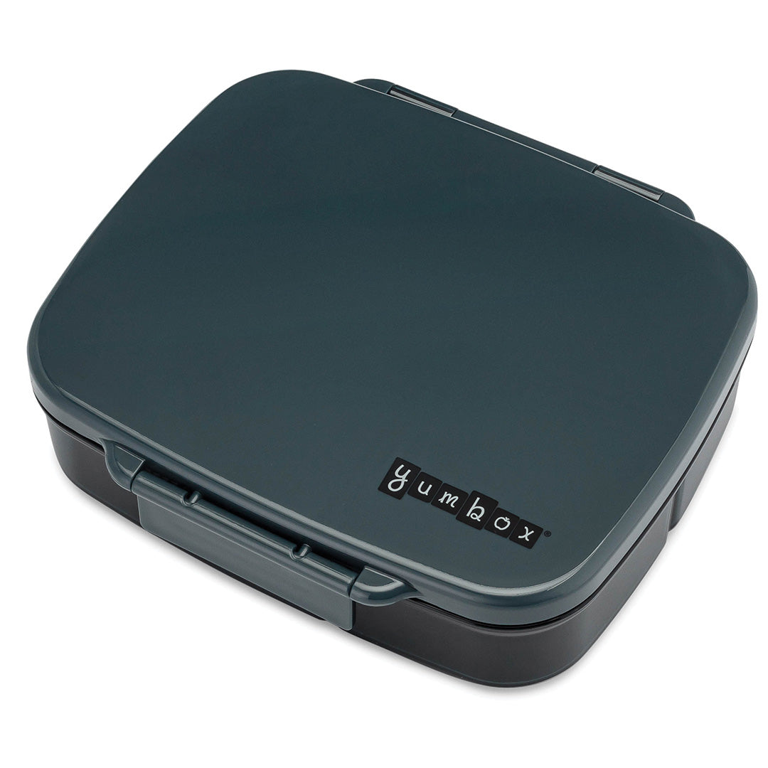 Yumbox bento broodtrommel in donkergrijs, gesloten, met het logo op de deksel.