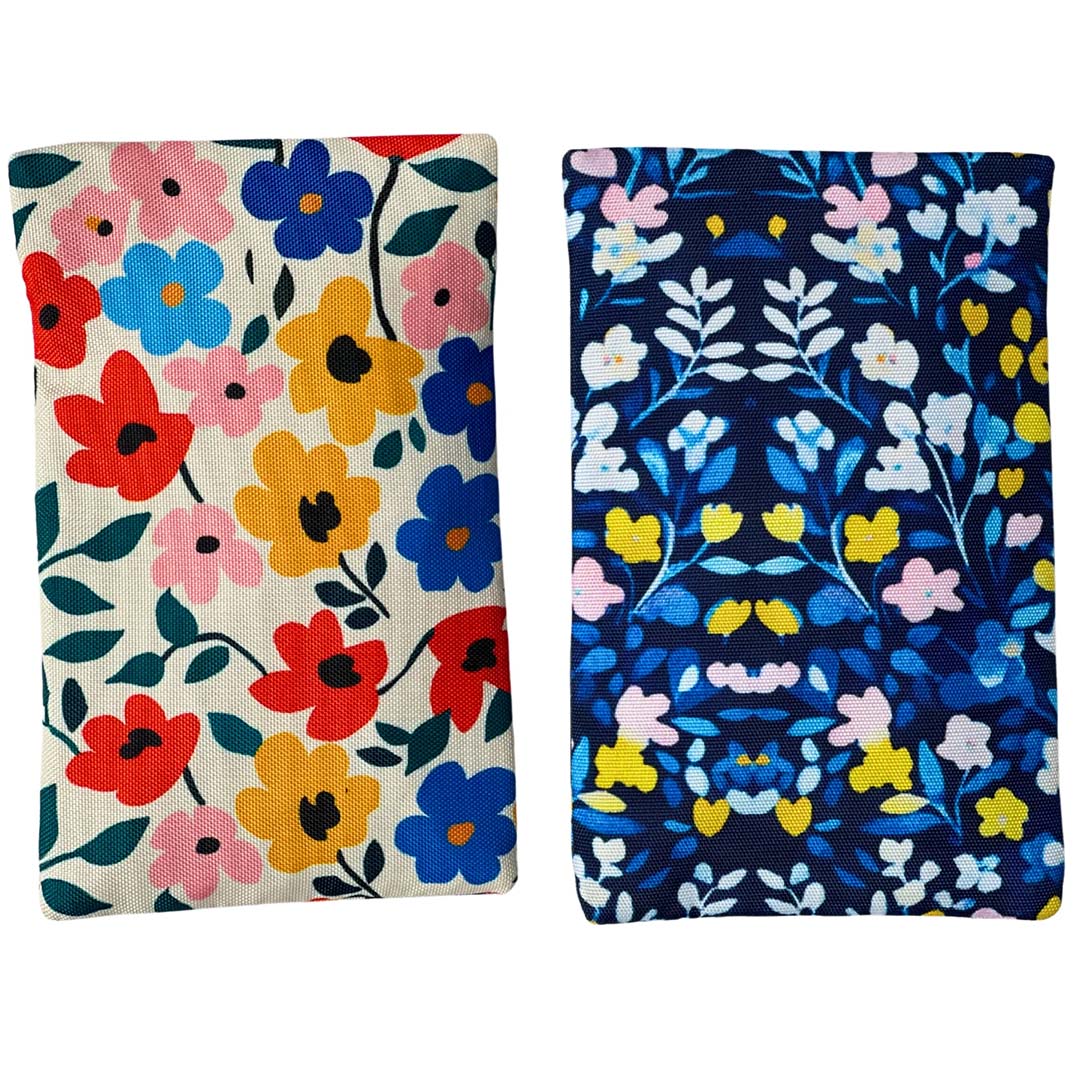 Twee Yumbox koelelementen met verschillende bloemenpatronen, één met lichte achtergrond en één met donkerblauwe achtergrond.