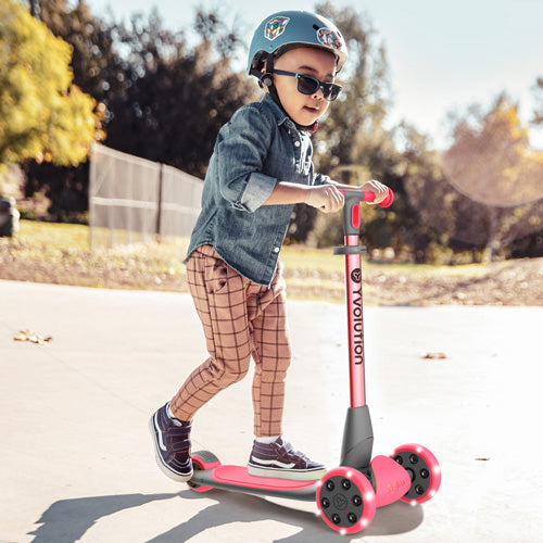 Een kind met helm en zonnebril rijdt op de Yvolution rode kinderstep met verlichte wielen.