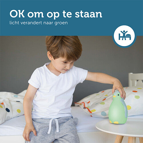 Infographic over de Zazu slaaptrainer die groen licht geeft wanneer het tijd is om op te staan, met een kind dat de pinguïn aanraakt.