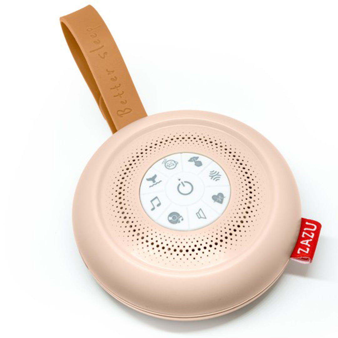 Zazu beige ronde geluidsmachine met bedieningsknoppen en een bruine ophanglus, schuin van bovenaf gefotografeerd.