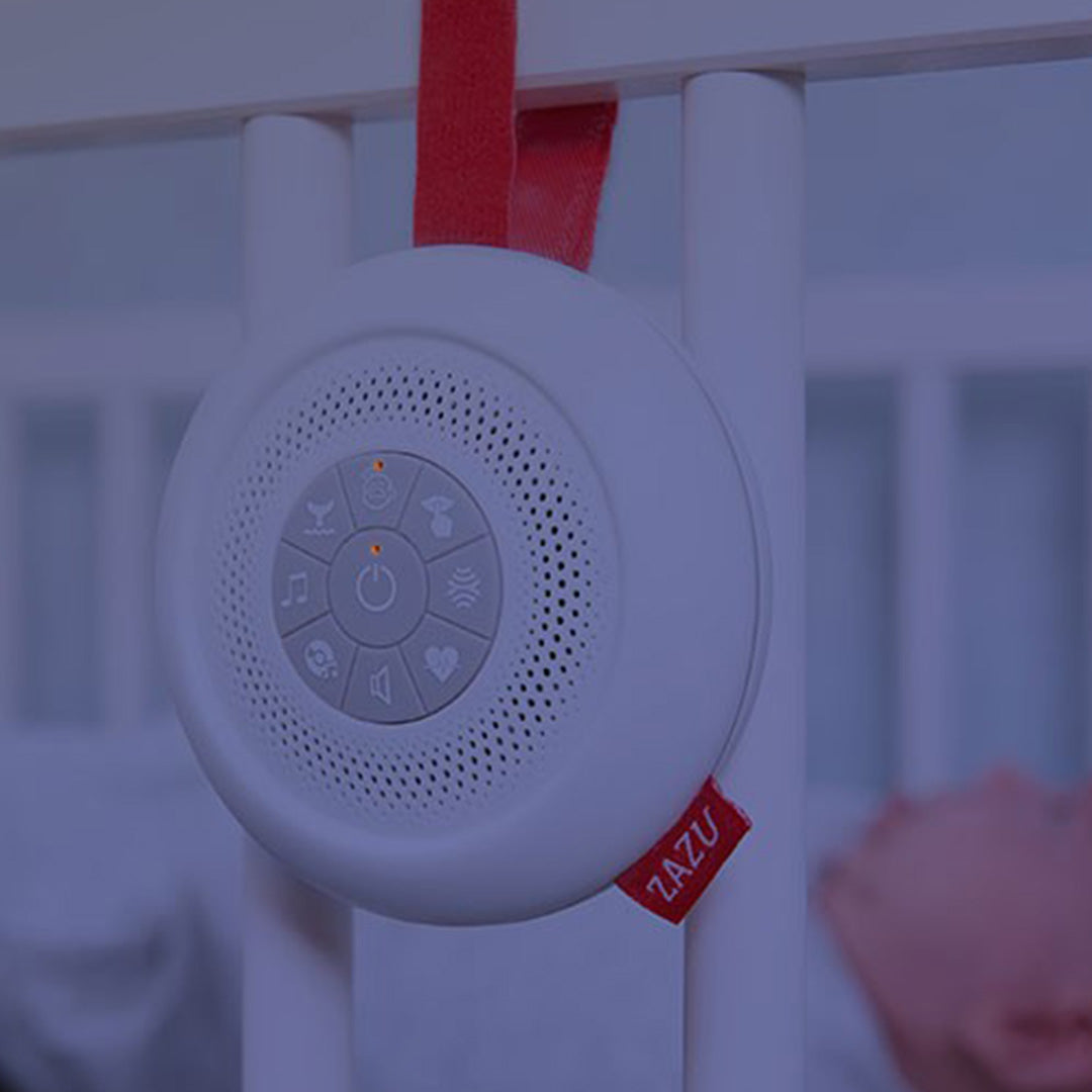 Zazu muziekdoosje Suzy hangt aan de spijlen van een babywieg in een donkere kamer.