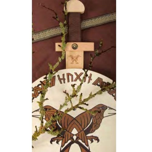 Detail van het houten Viking speelgoedzwaard met een schild met vogelpatroon en runen.